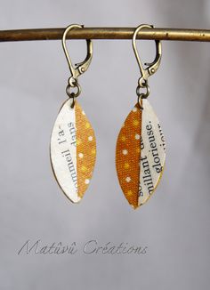 two pairs of earrings with words on them hanging from a hook - off chain,