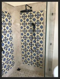 a bathroom with blue and white tiles on the shower wall