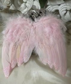 a pink feather angel wings on a bed