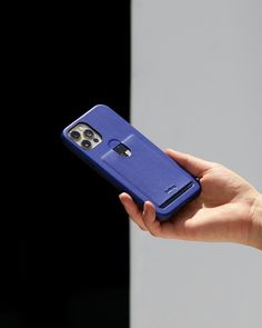 a hand holding a blue cell phone in it's left hand with the back cover open