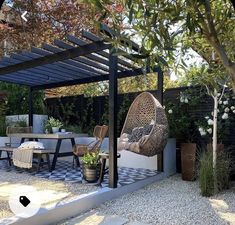 an outdoor dining area with chairs, tables and a hammock hanging from the roof