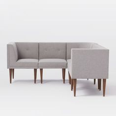 two gray couches sitting next to each other on top of a white flooring