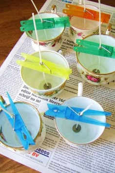 several small cups with toothpicks in them sitting on top of a newspaper