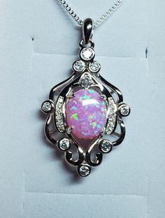 "Pretty Pink Opal Chandelier Design Necklace, 8x10mm Lab Created Opal See Video!  925 Sterling Silver Pendant, Rhodium Plated, With Pave' And 9 Cubic Zirconias. 18\" Sterling Chain, Chain Length Options Available By Messaging Seller At Time Of Purchase. Gift Box Included." Silver Cubic Zirconia Necklace With Stone Setting, Silver Oval Necklace With Sparkling Stones, Dazzling Sterling Silver Oval Pendant Necklace, Sterling Silver Necklace With Bail For Anniversary, Sterling Silver Necklace With Bail As A Gift, Silver Oval Necklace With Bail, Silver Necklace With Bail In Fine Jewelry Style, Dazzling Oval Silver Necklace, Chandelier Necklace