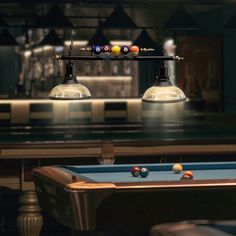 two billiards tables with pool balls hanging from them