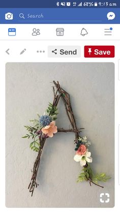 a twig with some flowers on it and the letter s is made out of twigs