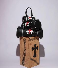 two black and white bags sitting on top of a piece of wood next to each other