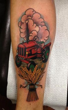 a man's leg with a tractor on it and clouds in the sky above