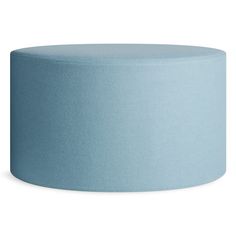 a light blue round ottoman sitting on top of a white floor next to a wall