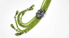 "Peridot Lariat Necklace, Long Tassel Necklace, Rhinestone Fringe Necklace, Art Deco Lariat, Glass Bead Tassel Necklace, Heidi Daus Vintage Excellent Condition Measurements: 18\", tassel adds an additional 11\" length for a total of 29\" Metal: Bronze tone Findings: Slide lock, easy on easy off! Finish: Polished, Oxidized This is an INCREDIBLE vintage find! Made by Heidi Daus in the 1980s, this original slide lock closure piece has been retired for DECADES and is SO RARE and SO STUNNING and SO LONG. TWENTY-NINE total inches of original shape peridot green faceted glass beads with a COMPLETELY SWAROVSKI ENCRUSTED pendant at the center of it all. Shades of crystal include amethyst, tanzanite, blue topaz, aquamarine, and champagne diamond all HANDSET in oxidized and textured bronze metal. Don Unique Green Lariat Necklace, Elegant Faceted Lariat Necklace, Multicolor Hand-strung Lariat Necklace, Hand-strung Multicolor Beaded Lariat Necklace, Vintage Long Beaded Necklaces, Hand-strung, Crystal Tassel Necklace, Long Tassel Necklace, Heidi Daus, Beaded Tassel Necklace