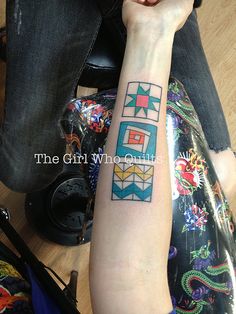 a woman with a colorful tattoo on her arm and wrist is sitting in front of a camera