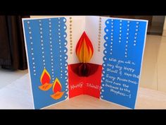 an open card with a lit candle on it and some words that say happy diwaling