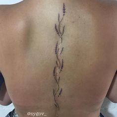 the back of a woman's shoulder with lavender flowers on her left arm and lower back