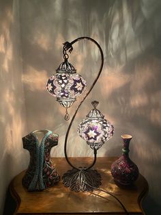 a table with three vases and a lamp on it