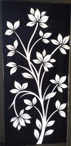 a black and white wall hanging with flowers on it's side, in the shape of a tree