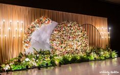 a stage with flowers on it and lights in the background at a wedding reception or event