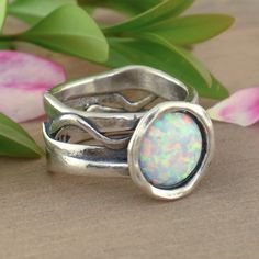 Our White Opal Ring comes to you in sterling silver & reconstructed opal. This designer piece shines in both the band design and the iridescent center stone. The band is well-proportioned, measuring approximately 13.5mm in the front and about 9mm around. The featured center stone is a bezel set round opal measuring 10mm (about 4 carats). Our White Opal Ring captures all the beautiful shades of opal. Metal: .925 Sterling SilverFinish: Oxidized/AntiquedStones: Reconstructed OpalMSRP: $114.99Part o White Opal Ring, Antique Stone, Band Design, Opal Ring, Size 10 Rings, White Opal, White Ring, Opal Rings, Bezel Setting