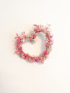 pink and white flowers arranged in the shape of a heart on a white background with space for text