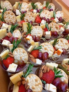 several trays filled with crackers, cheese and fruit on top of each other