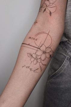 a woman's arm with flowers and the word faith tattooed on her left arm