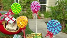 many lollipops are on display in front of a house with presents wrapped around them