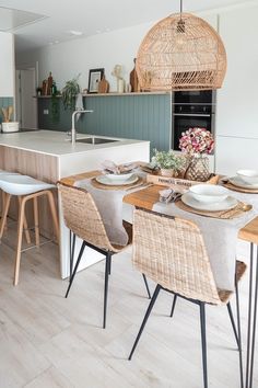 a dining room table with chairs and plates on it