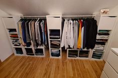 an organized closet with clothes and drawers