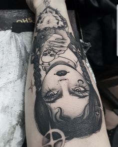 a woman's arm with a black and white tattoo design on her left arm