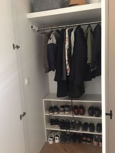 an open closet with shoes and coats on shelves