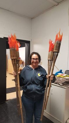 a woman holding two fire torches in her hands