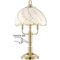 a brass table lamp with white glass shades