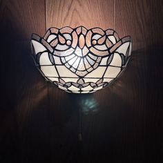 a stained glass light fixture on a wooden wall