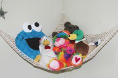 several stuffed animals are sitting in a hammock