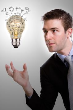 a man in a suit is holding his hand out to an idea lightbulb