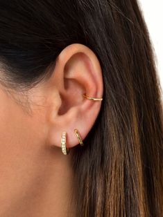 a close up of a woman's ear with two small diamond hoops on it