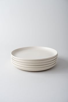 four white plates stacked on top of each other