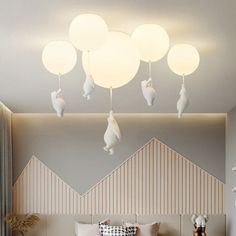 a bed with pillows and lamps hanging from the ceiling