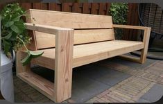 a wooden bench sitting next to a potted plant