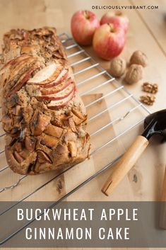 an apple cinnamon cake sitting on top of a cooling rack next to some apples and nuts