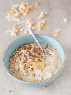 a bowl filled with oatmeal and nuts on top of a white table