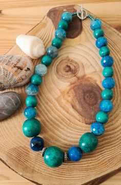 "Blue Azurite  Mixed Glamrox Stone Wood Necklace. Glamrox Mixed Boho Blue Green Beaded Necklace. Ocean Exotic Blue Green Necklace Beautiful array of blue and green gemstone and wood beads! Striking color! Original one of a kind handmade Glamrox designs:-) Necklace measures: 17 inches long. Silver tone toggle closure. A lovely gift!  *If you have have any questions regarding this item, please hit the \"Ask a Question\" button next to the price and I will get back to you within 24 hours:-) We prid Blue Agate Polished Bead Necklaces, Blue Agate Beaded Necklace With Polished Beads, Blue Agate Polished Beads Necklace, Blue Agate Beaded Necklaces, Blue Agate Beaded Necklace, Blue Agate Round Beads Necklace, Blue Chrysocolla Gemstone Beaded Necklaces, Blue Agate Beaded Necklaces With Natural Stones, Hand-strung Blue Turquoise Chrysocolla Necklace