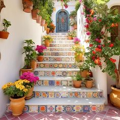 a set of steps with potted plants and flowers on each step leading up to the door