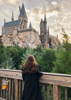 a woman looking at hogwarts castle in the distance