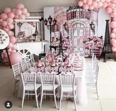 a table set up for a party with pink and white balloons on the wall behind it