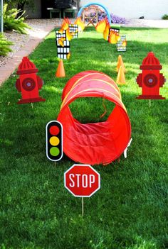 a red tent sitting on top of a lush green field next to fire hydrants