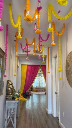 a hallway decorated with yellow and pink streamers hanging from the ceiling, along with other decorations