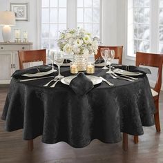 a dining room table is set with silverware and flowers