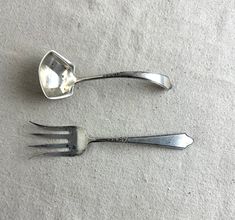 two forks and spoons sitting on top of a white cloth covered floor next to each other