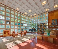 a large living room with lots of windows on the ceiling and furniture in front of it