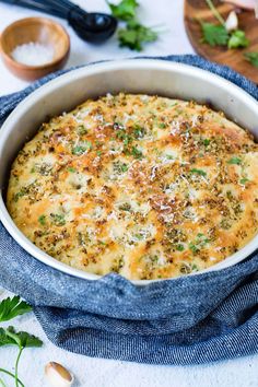 a casserole dish with cheese, herbs and seasonings in it on a blue cloth